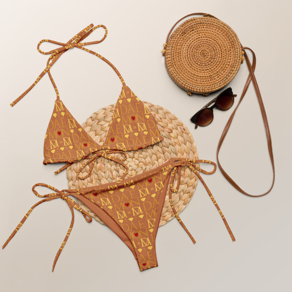 Daemon Luxury Tarmin Dim (Sun Glow) Dulce Scusa all-over-print recycled string bikini in white, front view showing vibrant design.