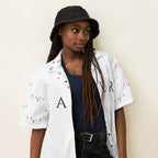 All-over print unisex button shirt by Daemon Luxury, white fabric with colorful pattern, shown from right front.