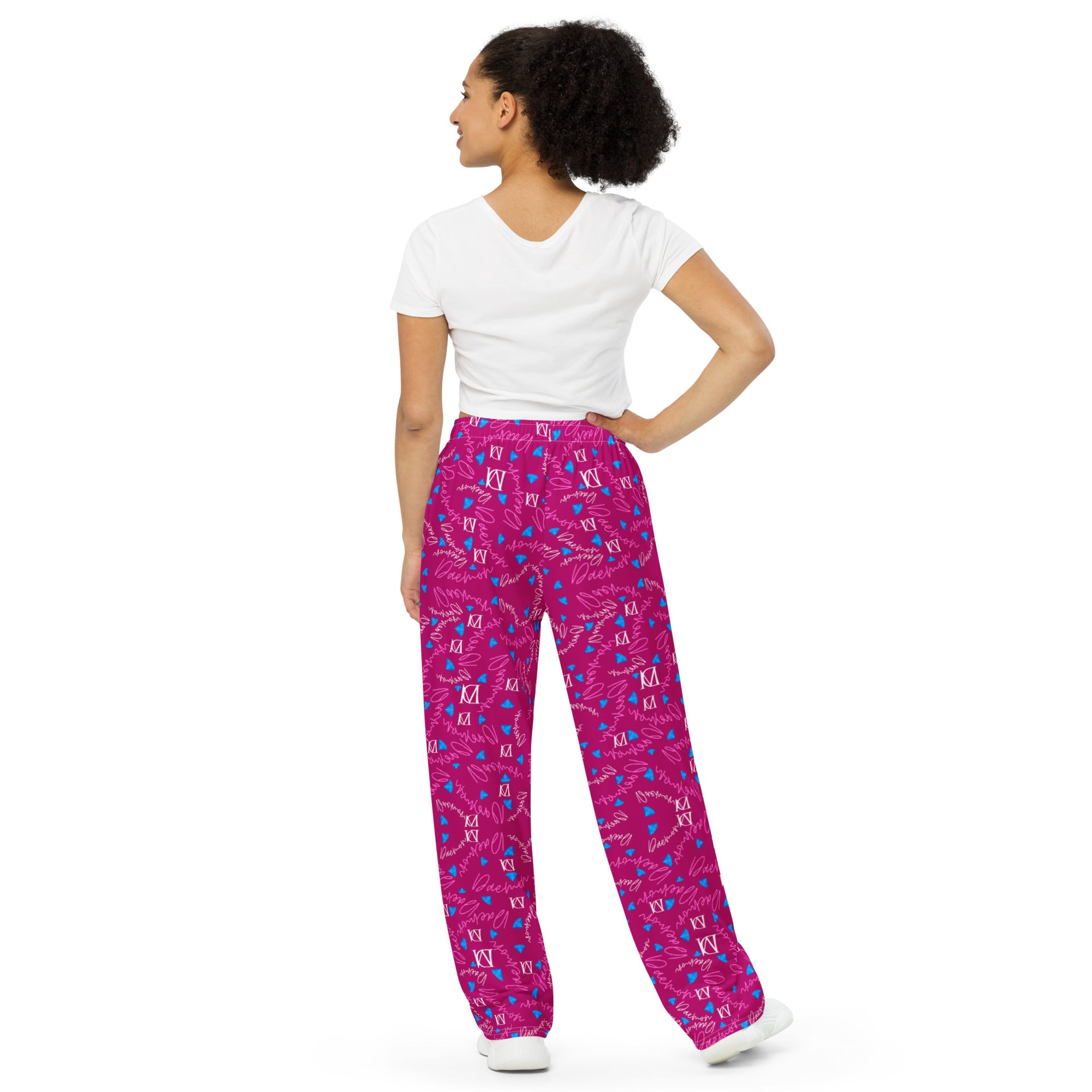Unisex wide-leg pants with all-over magenta Picasso mirror print by Daemon Luxury, shown from the back.