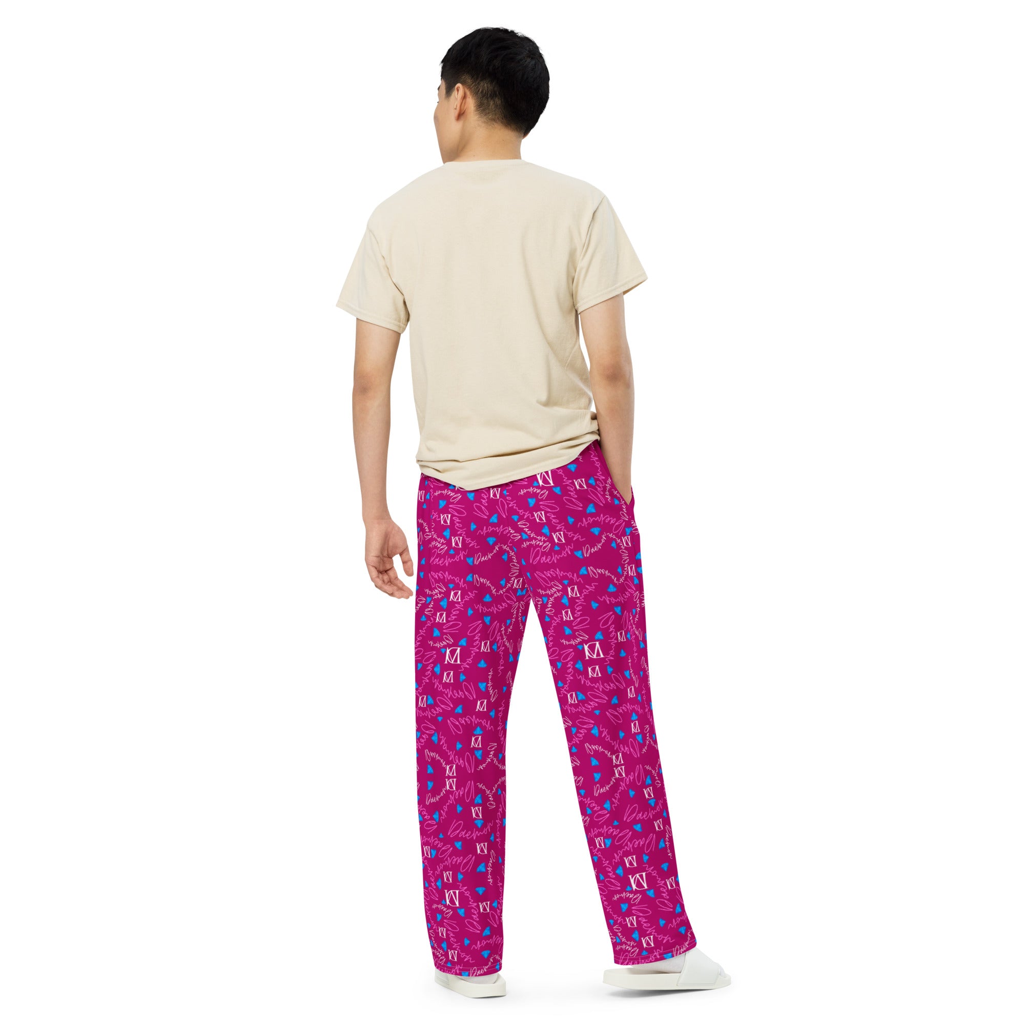 Unisex wide-leg pants with all-over magenta Picasso mirror print from Daemon Luxury, shown from the back on a white background.
