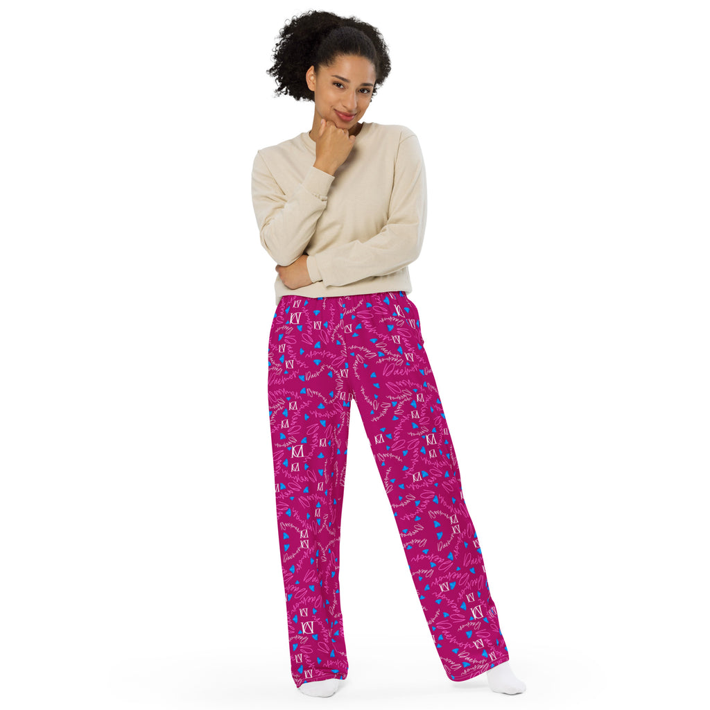 Unisex wide-leg pants with all-over magenta Picasso mirror print by Daemon Luxury, front view on white background.