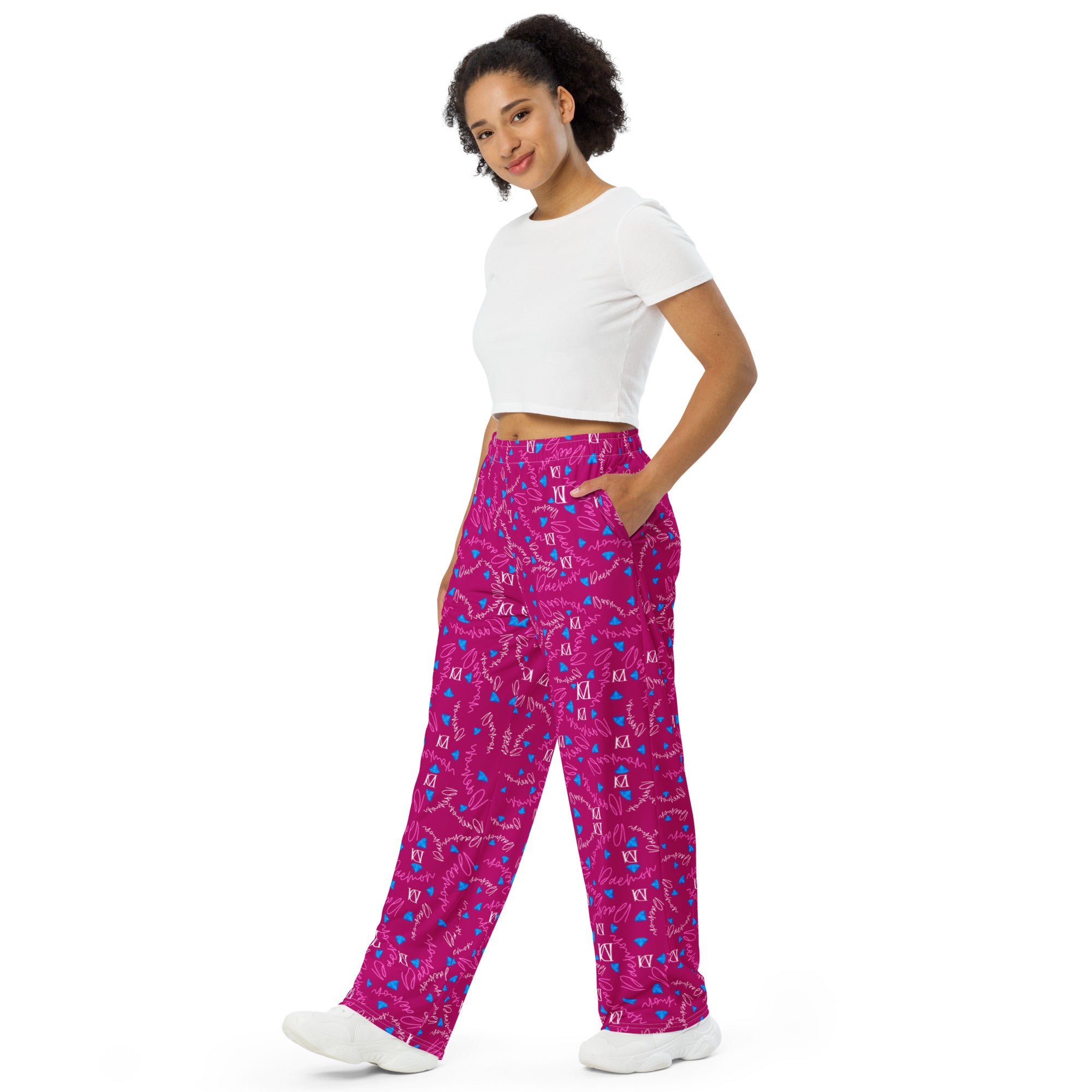 Unisex wide-leg pants with all-over magenta Picasso mirror print by Daemon Luxury, seen from the front on white background.