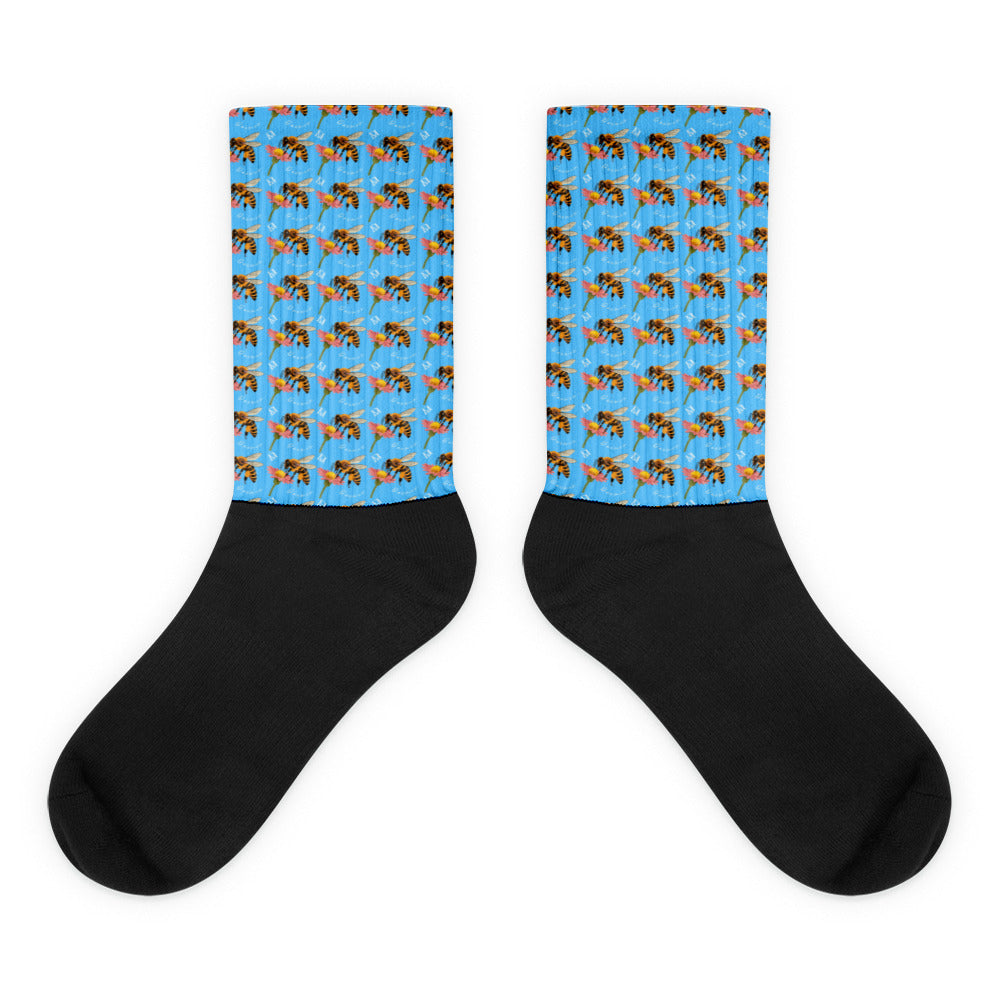 Black sublimated socks featuring honeybee and shores design from Daemon Luxury's Honeybee Shores Pacifica Fever collection.