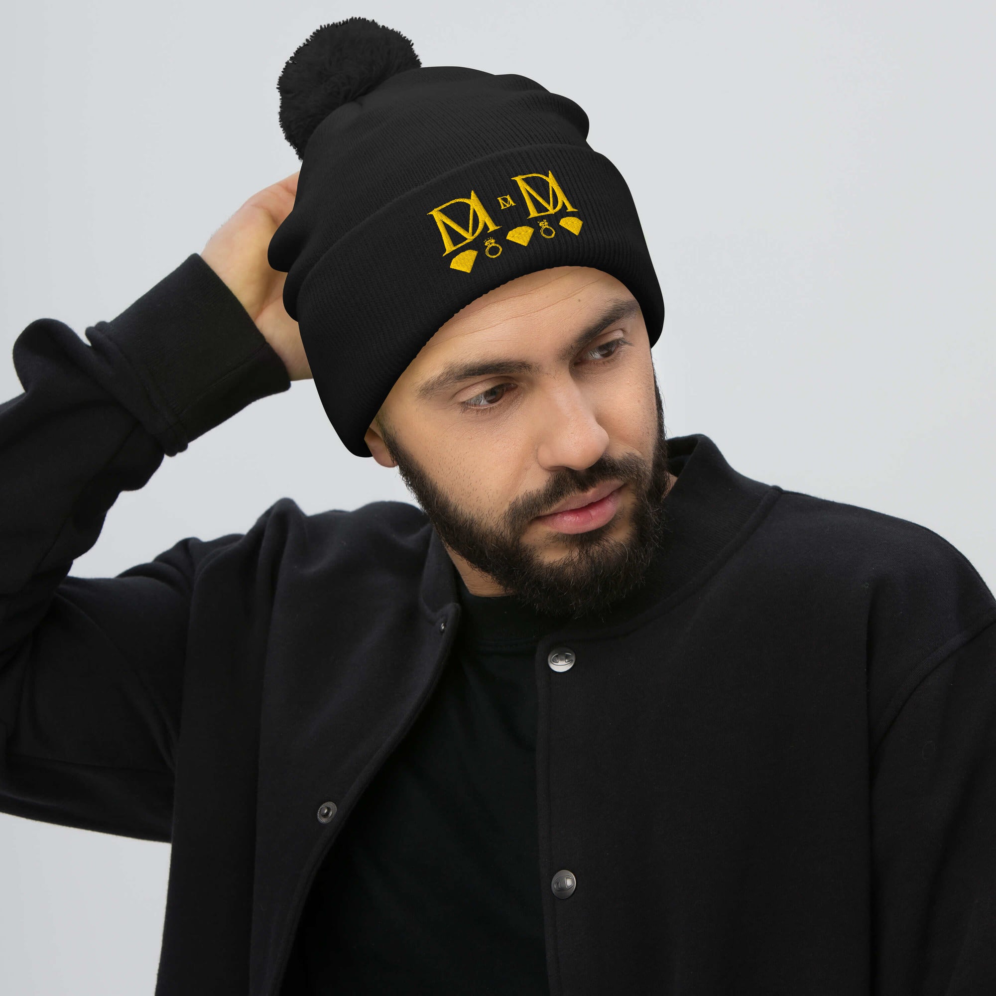 Daemon Luxury Nemesis Sun Glow .2 pom-pom knit cap in black, front view showing cozy woolen fabric and stylish design.