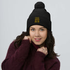 Daemon Luxury Nemesis Sun Glow black knit wool beret with pom-pom detail, front view showing cozy, stylish winter headwear.