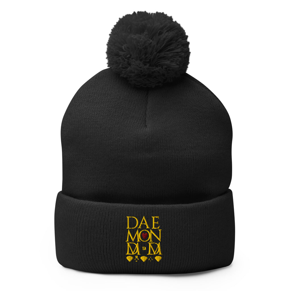 Daemon Luxury Nemesis Sun Glow black pom-pom-knit beanie cap, front view showcasing cozy wool texture and stylish design.