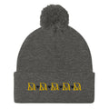 Daemon Luxury Stormless Dim Sun Glow pom-pom-knit wool cap in dark heather grey, front view showcasing cozy winter style.