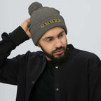 Daemon Luxury Stormless Dim Sun Glow berretto lana with pom-pom knit in dark heather grey, front view showcasing cozy winter style.