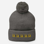 Daemon Luxury Stormless Dim Sun Glow pom-pom-knit wool cap in dark heather grey, showcasing front view and cozy knit texture.