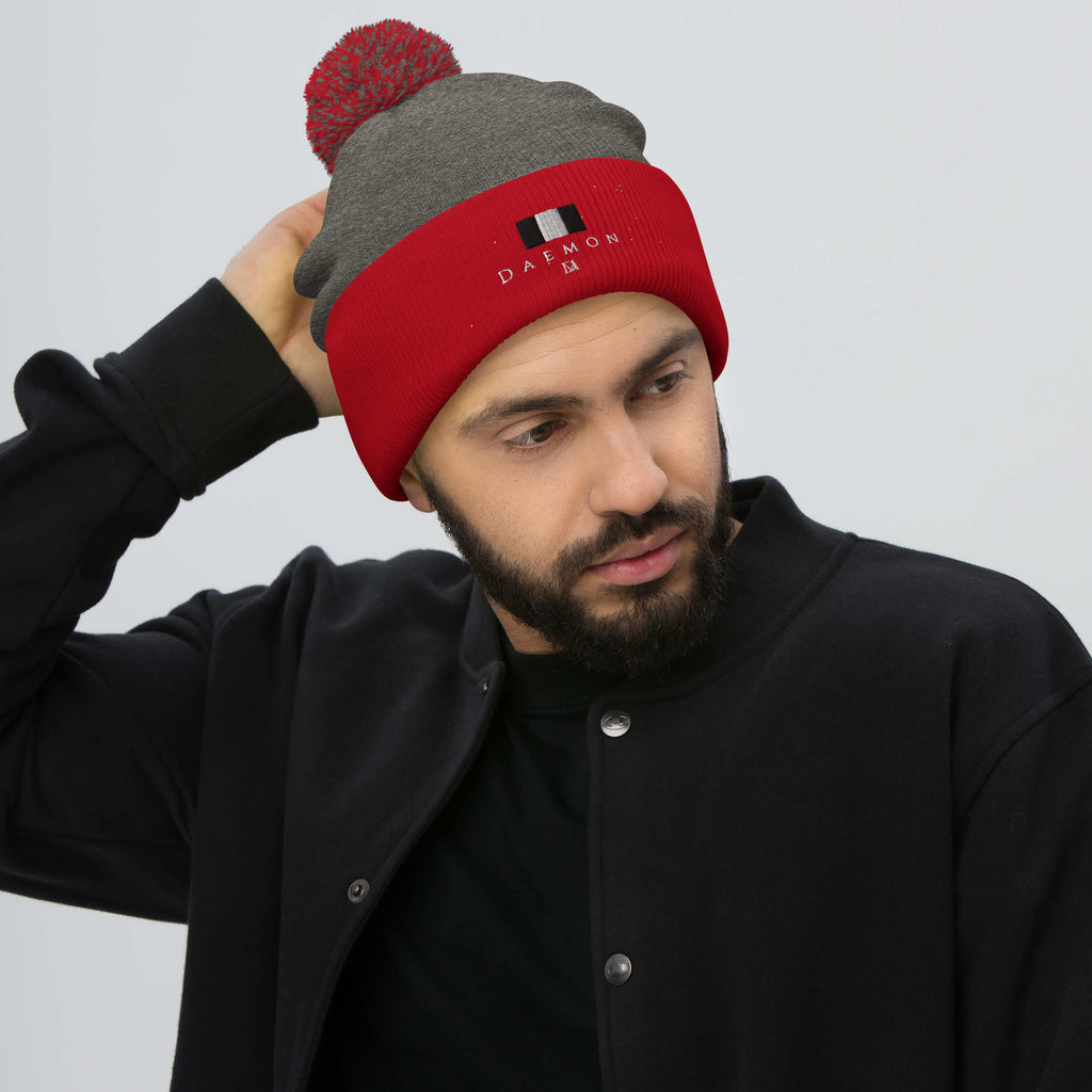 Daemon Luxury Lux Class Snow Light pom-pom knit cap in dark heather grey with red accents, cozy wool beanie for winter warmth