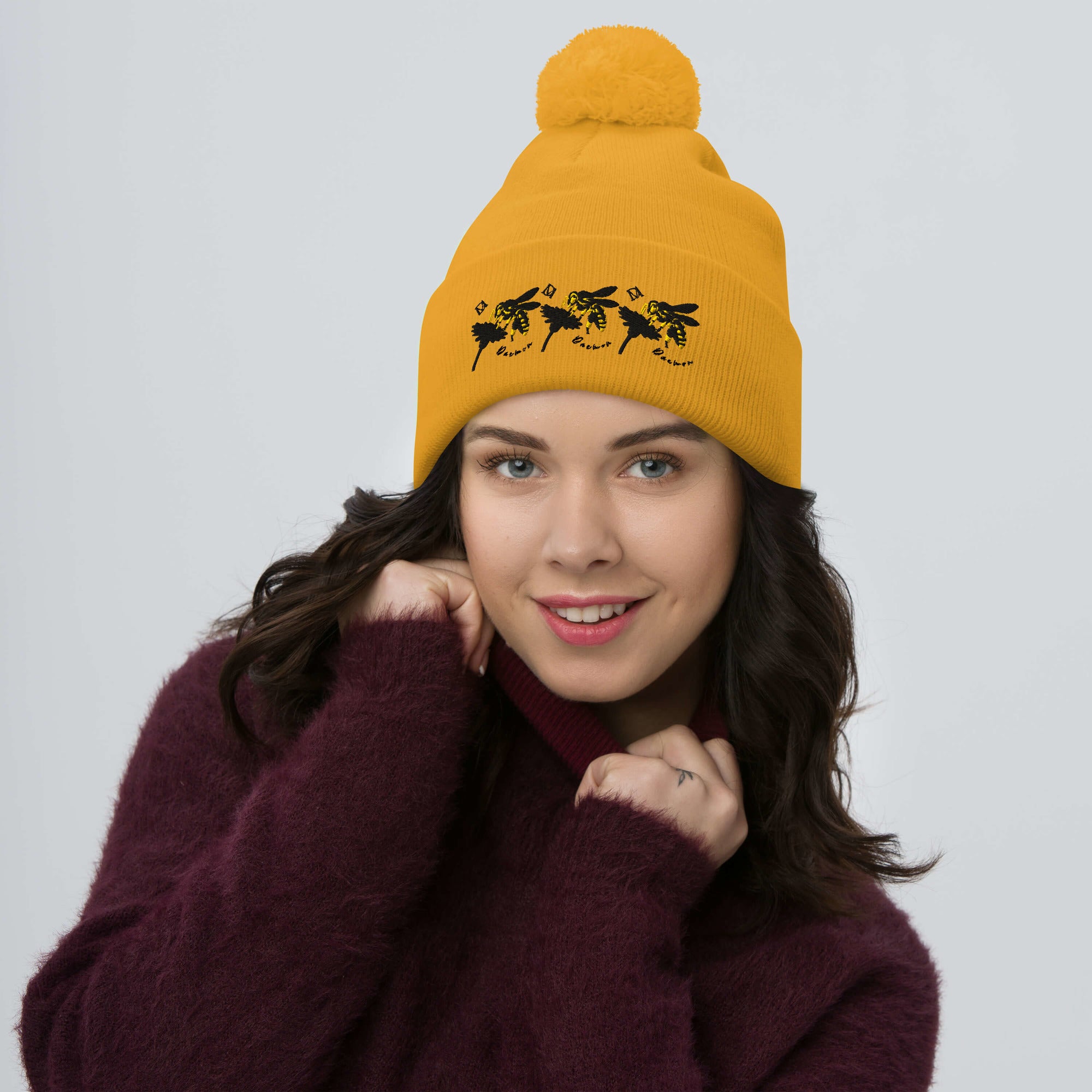 Golden pom-pom knit cap by Daemon Luxury from Honeybee California G.T. Caped Heroes collection, featuring a front view.
