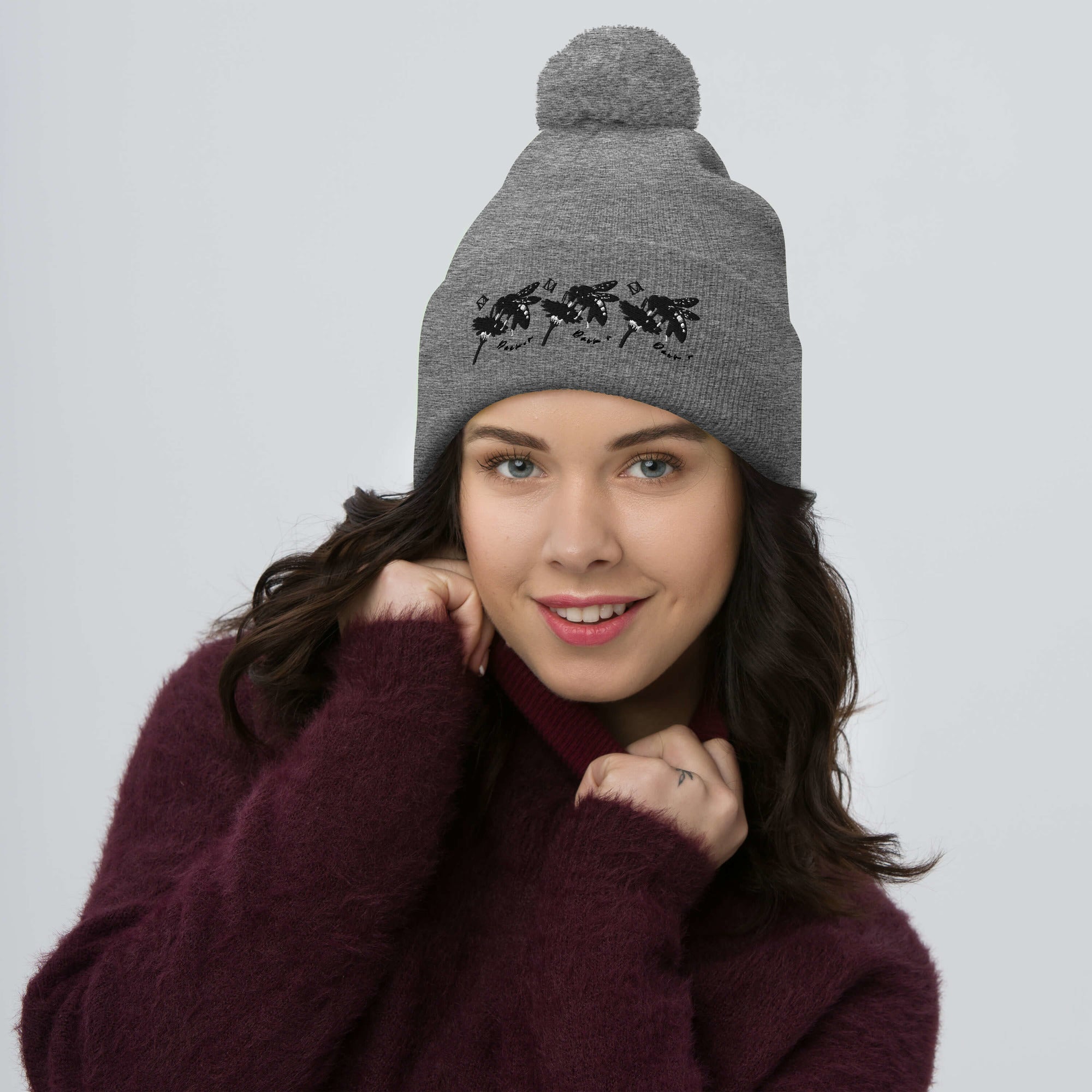 Daemon Luxury Stormless connectivity wool pom-pom knit cap in heather grey, showcasing front view with cozy texture.
