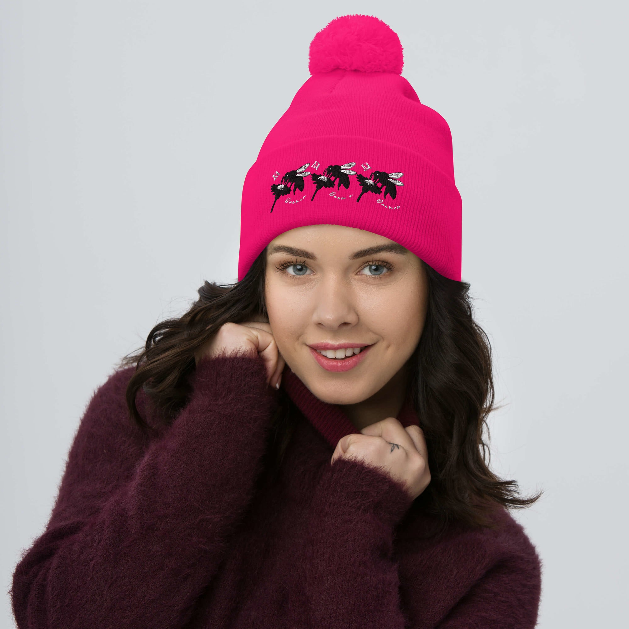 Daemon Luxury stitched candies pom-pom knit cap in neon pink, showcasing a cozy wool design with a front view.