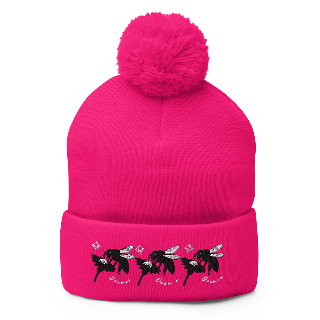 Neon pink pom-pom knit cap by Daemon Luxury featuring stitched candies pattern on front, cozy lana design.