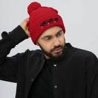 Red pom-pom knit cap from Daemon Luxury's Flash of Red (Dim Sting) collection, featuring a cozy wool design and front view.