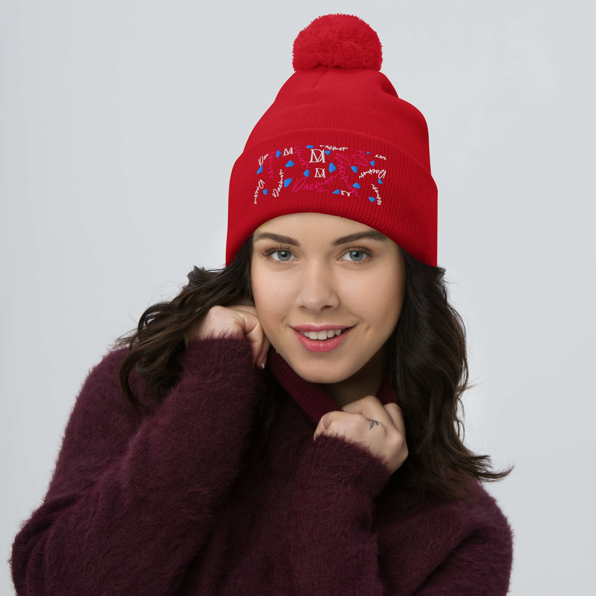 Red pom-pom knit cap from Daemon Luxury's Flash of Red Picasso Mirrors collection, featuring a cozy, stylish design.