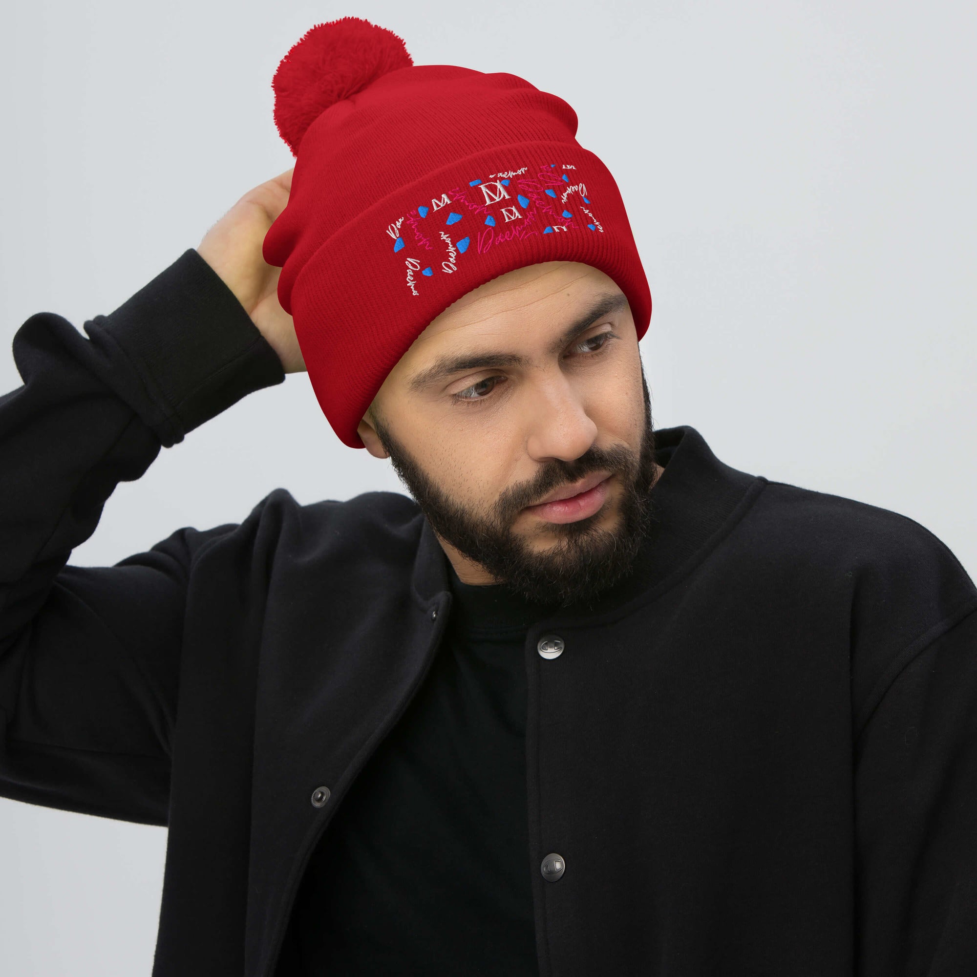 Red pom-pom knit cap from Daemon Luxury's Flash of Red Picasso Mirrors collection, featuring cozy wool material and front view.